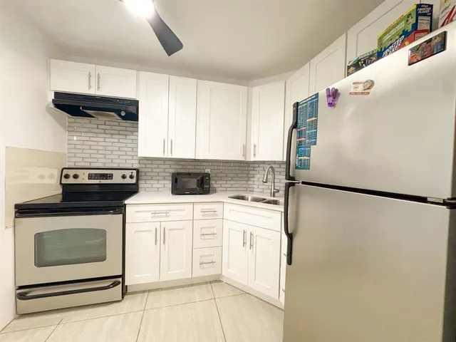 a white refrigerator freezer sitting in a kitchen