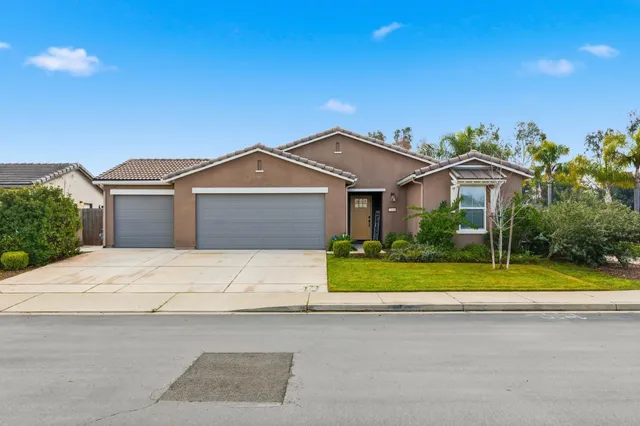 a front view of a house with a garden and yard