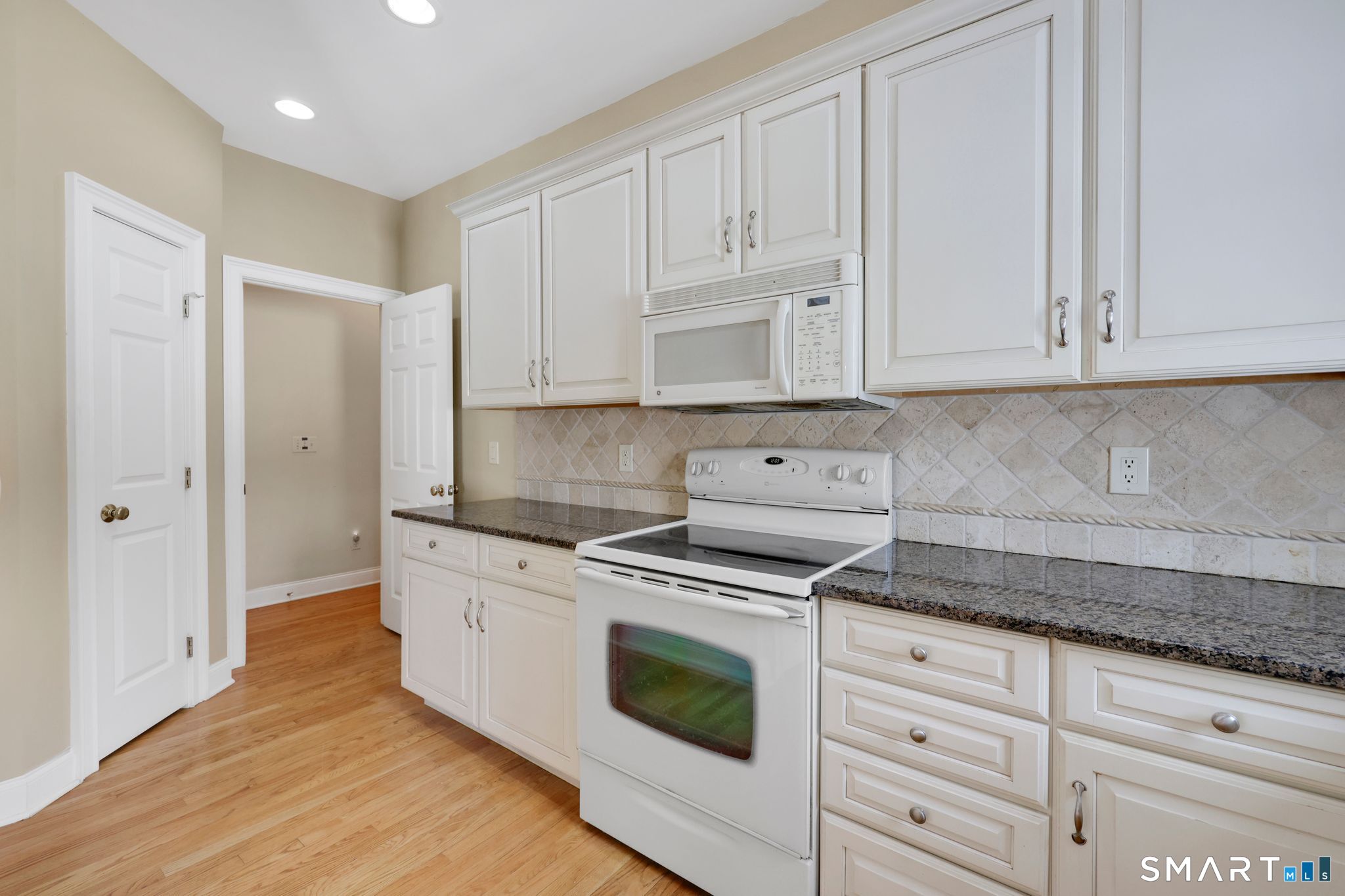 65 Trailside Drive Monroe, CT 06468 - Photo 15 of 39 a kitchen with granite countertop white cabinets and white appliances