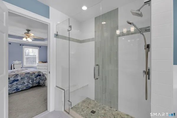 a en suite bathroom with a granite countertop sink a mirror and shower
