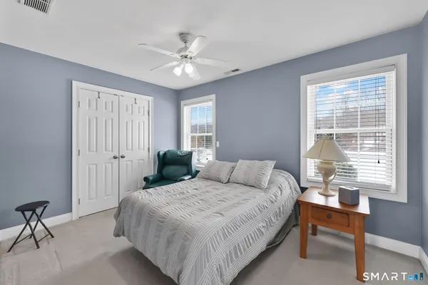 a bedroom with a large bed and a chandelier