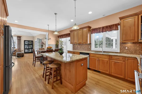 a kitchen with stainless steel appliances granite countertop a sink a stove and a refrigerator