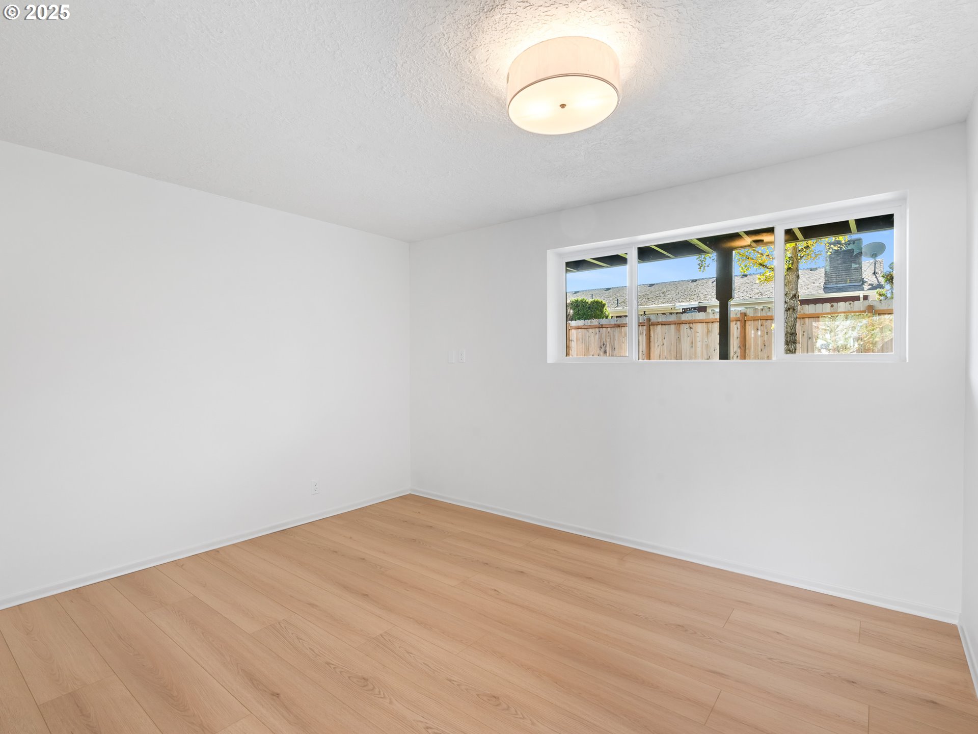 12942 Northeast Morris Street Portland, OR 97230 - Photo 18 of 28 a view of empty room with wooden floor