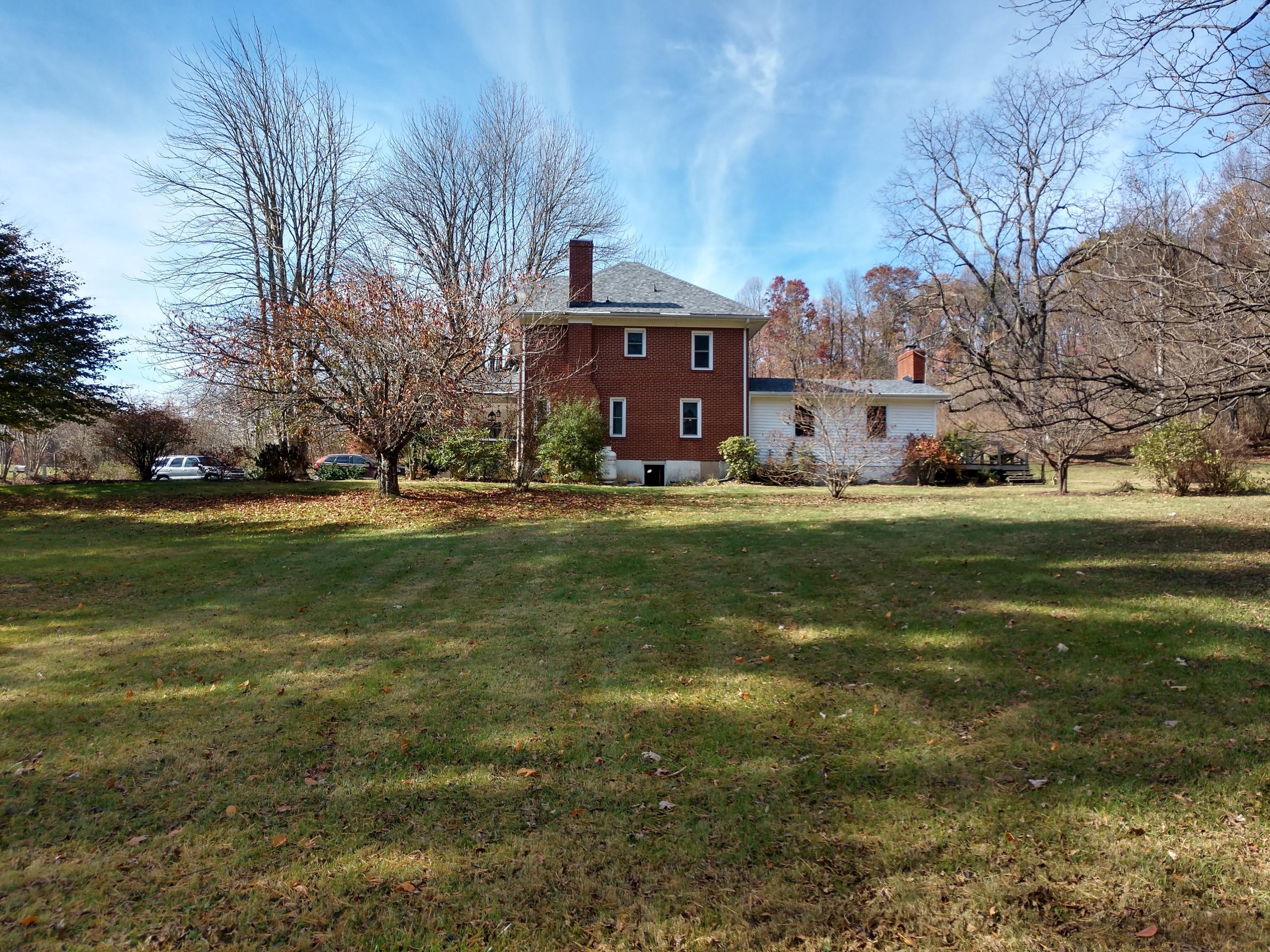 7909 Bear Ridge Road Southeast Copper Hill, VA 24079 - Photo 40 of 61 a view of a big house with a big yard and large trees