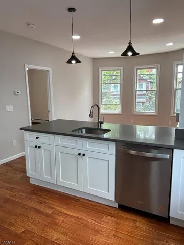a kitchen with granite countertop a sink and cabinets