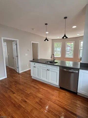 a large kitchen with granite countertop a large counter top space a sink a window and appliances