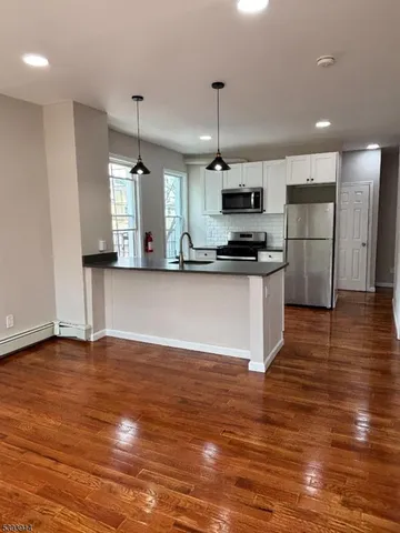 a kitchen with stainless steel appliances granite countertop a sink a stove top oven a counter space and cabinets