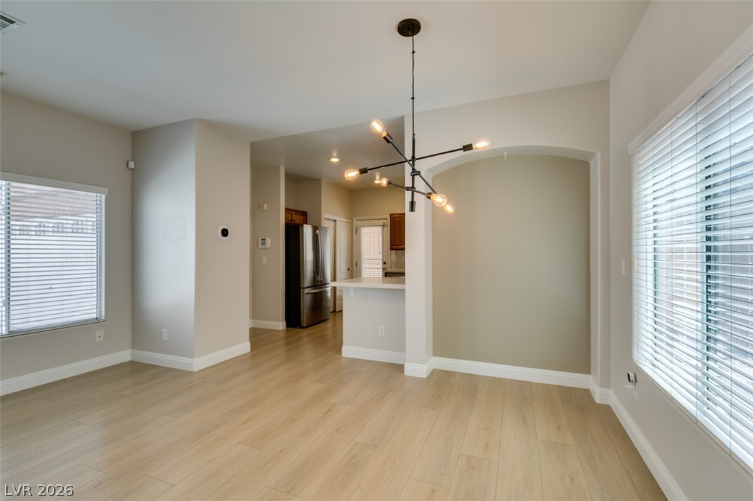 8909 Houston Ridge Avenue Las Vegas, NV 89178 - Photo 13 of 45 Blonde hardwood-style flooring extends through this airy, open-concept living and dining area.