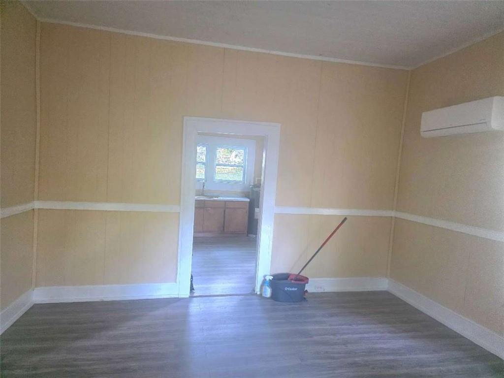 108 G Avenue Thomaston, GA 30286 - Photo 5 of 19 an empty room with wooden floor and windows