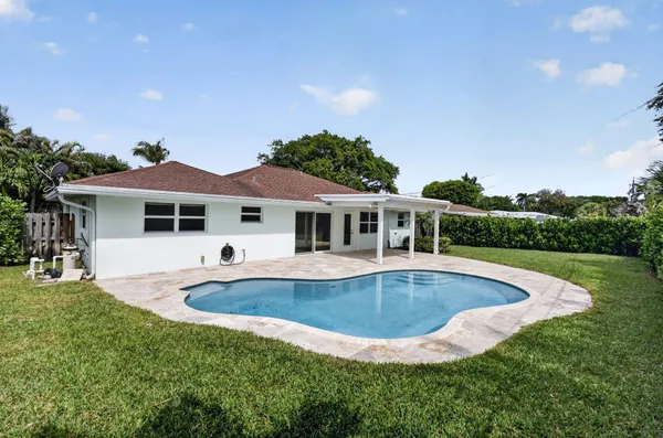 a view of a house with swimming pool and a yard