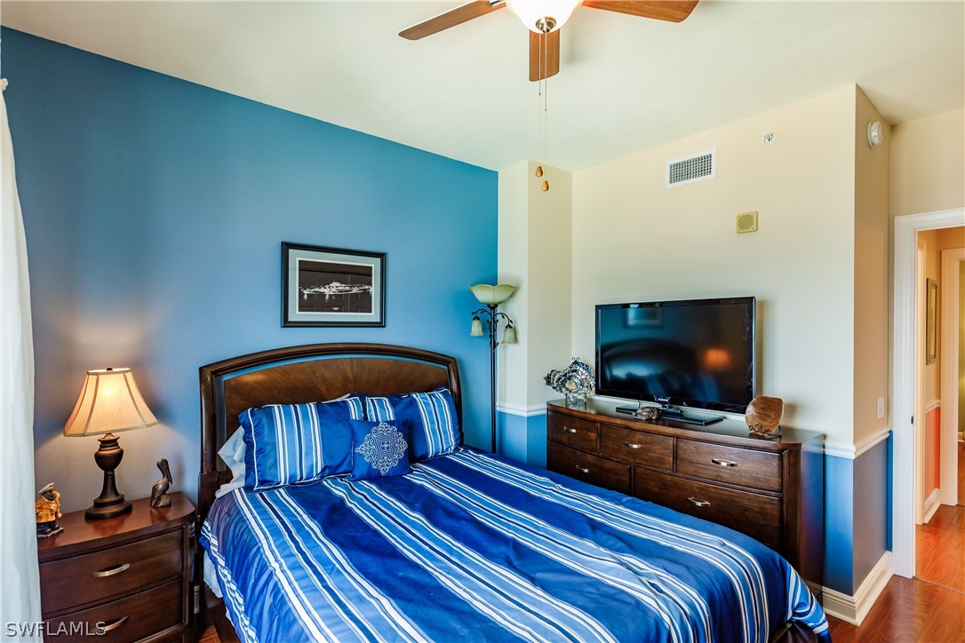 2743 First Street, Unit 704 Fort Myers, FL 33916 - Photo 13 of 17 a bedroom with a bed and a flat tv screen on the dresser