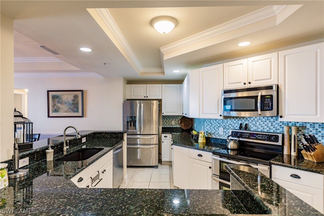 2743 First Street, Unit 704 Fort Myers, FL 33916 - Photo 8 of 17 a kitchen with stainless steel appliances a stove a sink a microwave a refrigerator a stove and white cabinets