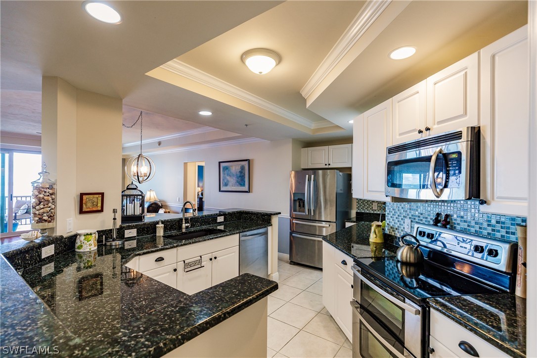 2743 First Street, Unit 704 Fort Myers, FL 33916 - Photo 9 of 17 a kitchen with stainless steel appliances granite countertop a stove and a sink