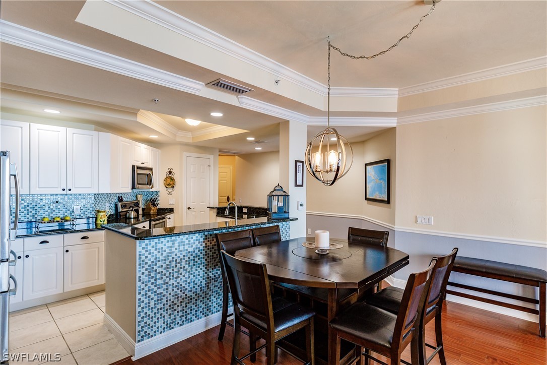 2743 First Street, Unit 704 Fort Myers, FL 33916 - Photo 10 of 17 a kitchen with granite countertop a table and chairs in it