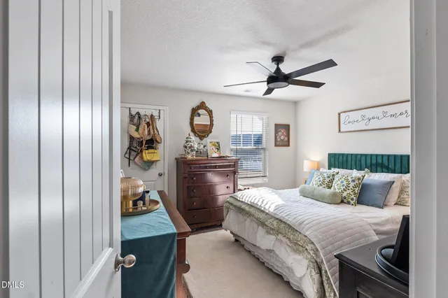 a bedroom with a bed and a flat tv screen on dresser