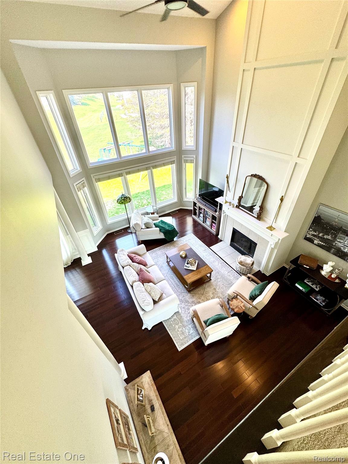 419 Roundview Drive Rochester, MI 48307 - Photo 25 of 29 Living area with a high ceiling, wood finished floors, a fireplace, and a ceiling fan