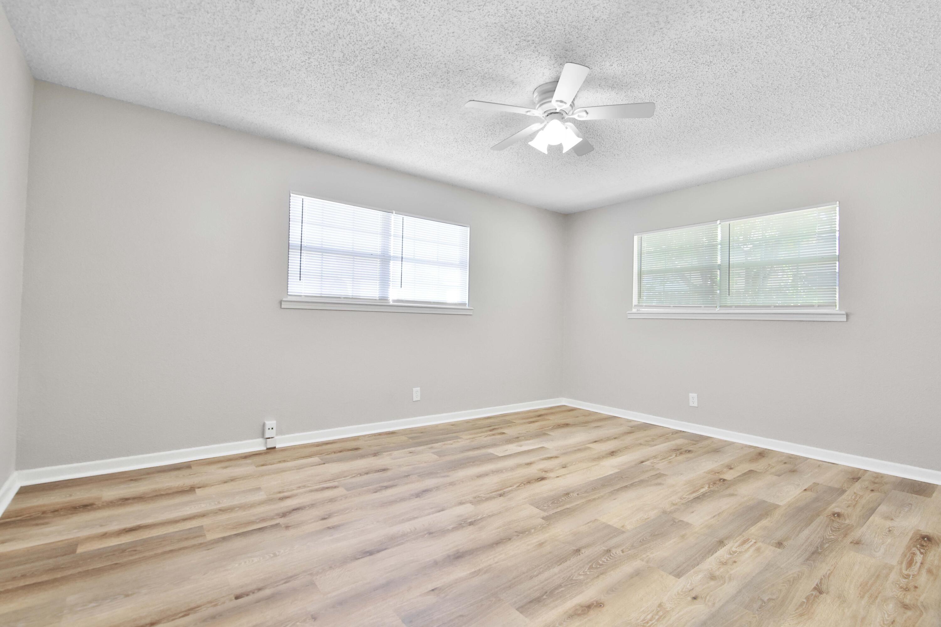 4310 42nd Street Lubbock, TX 79413 - Photo 17 of 30 a view of an empty room with wooden floor and a chandelier fan