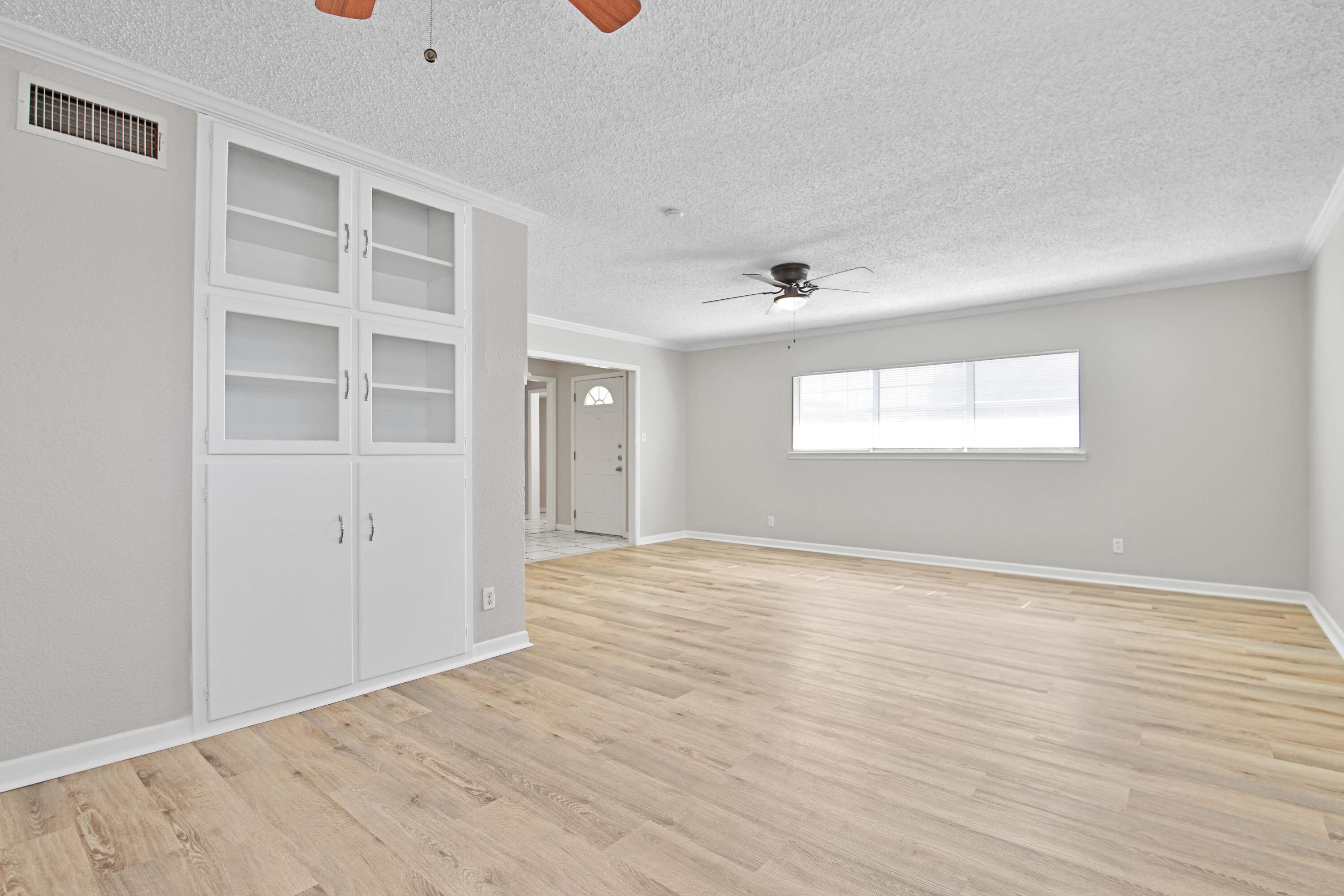4310 42nd Street Lubbock, TX 79413 - Photo 4 of 30 an empty room with wooden floor and windows