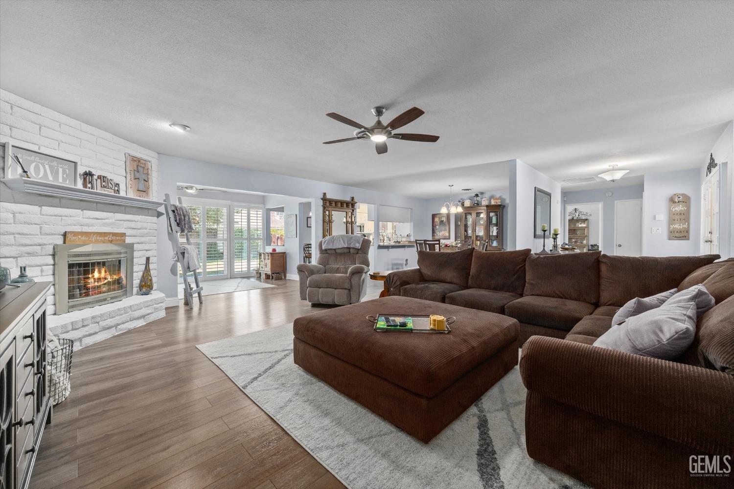 Undisclosed Address Bakersfield, CA 93309 - Photo 11 of 34 a living room with furniture a fireplace and wooden floor