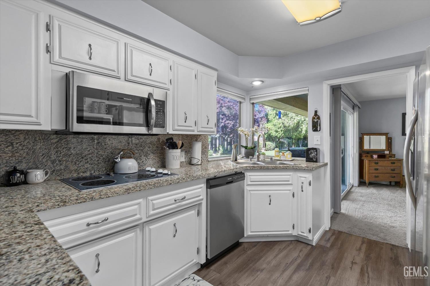 Undisclosed Address Bakersfield, CA 93309 - Photo 19 of 34 a kitchen with granite countertop cabinets stainless steel appliances and a wooden floor