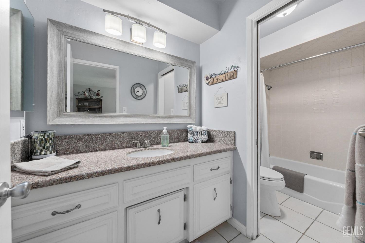 Undisclosed Address Bakersfield, CA 93309 - Photo 25 of 34 a bathroom with a granite countertop toilet sink and mirror