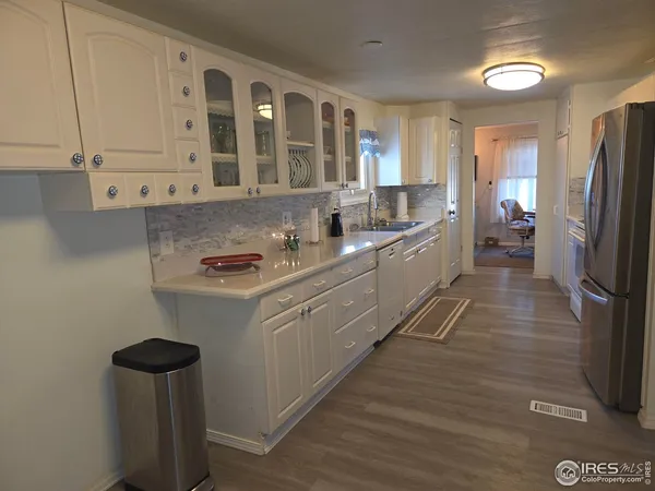 a kitchen with stainless steel appliances granite countertop a sink refrigerator and cabinets