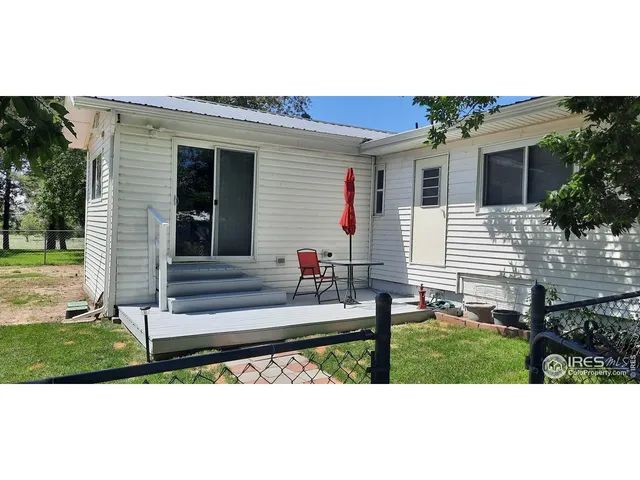 a view of a house with backyard and a tree