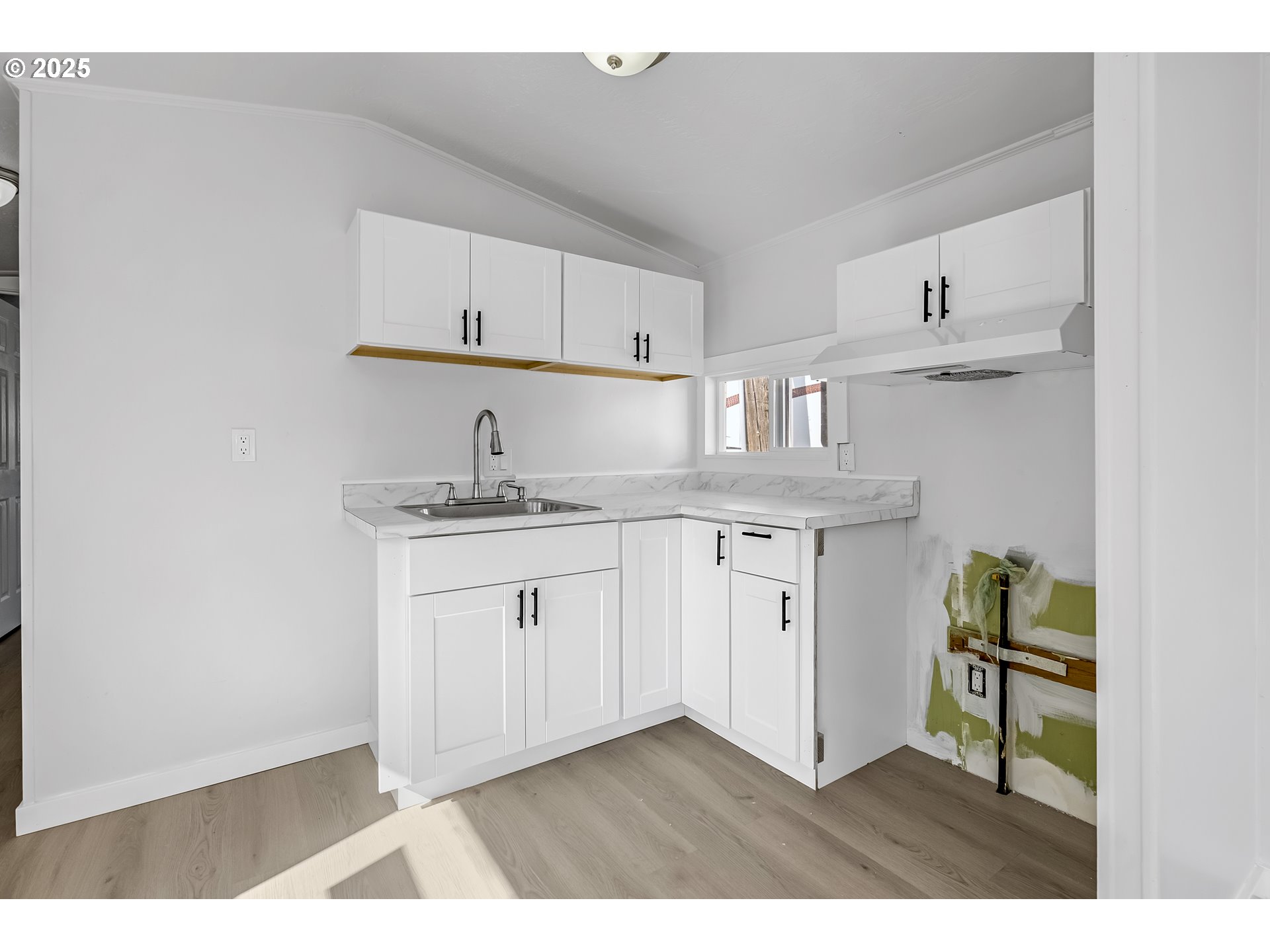 12726 Southeast Division Street, Unit 17 Portland, OR 97236 - Photo 11 of 26 a kitchen with cabinets and wooden floor