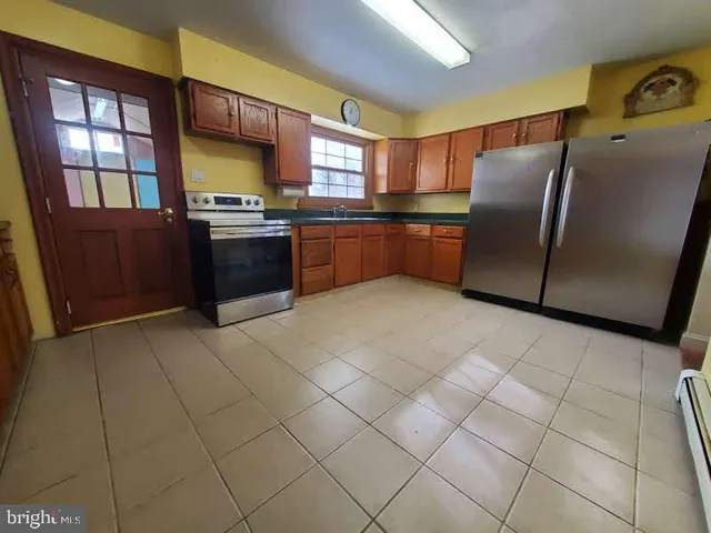 a kitchen with stainless steel appliances a refrigerator and a stove top oven