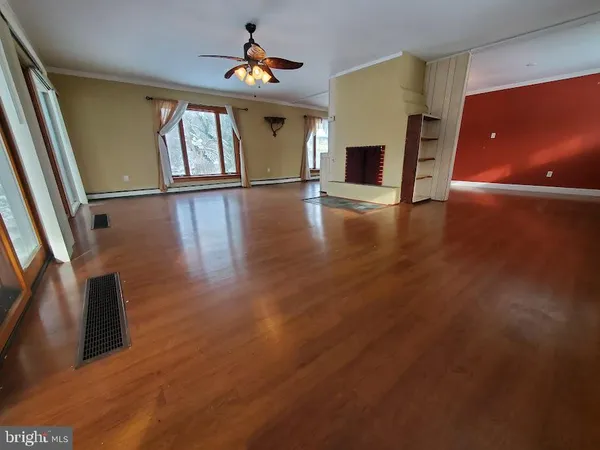 a view of a livingroom with wooden floor and fireplace