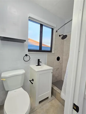 a bathroom with a toilet a sink and a mirror
