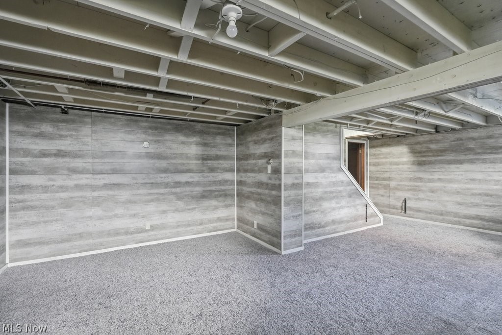 136 Pinehurst Road Munroe Falls, OH 44262 - Photo 32 of 48 Carpeted room featuring gray wood-finish paneling and an exposed ceiling with white-painted joists