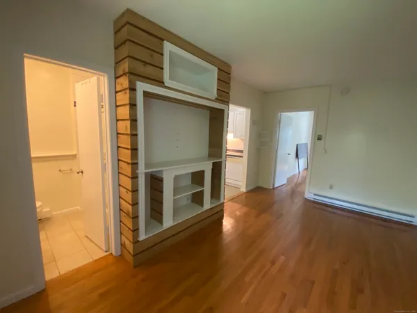 a living room with stainless steel appliances wooden floor and a window