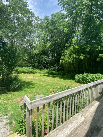 a view of a wooden deck and a yard with lawn chairs