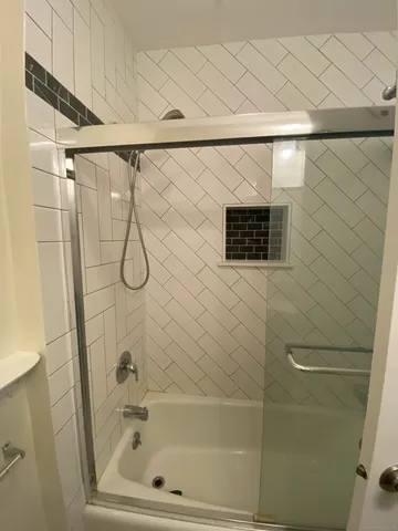 a bathroom with a shower and a glass door