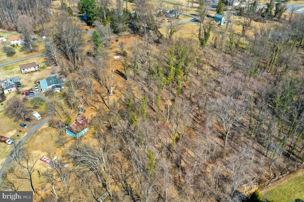 an aerial view of residential houses with outdoor space and trees