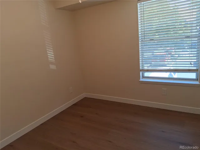 a view of a small space with wooden floor and a window