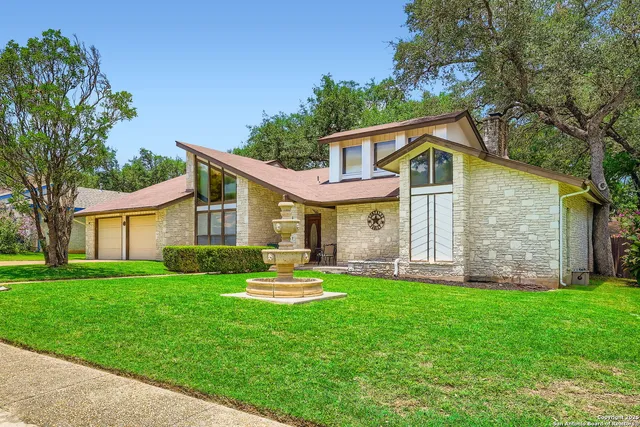 a front view of house with a garden and trees