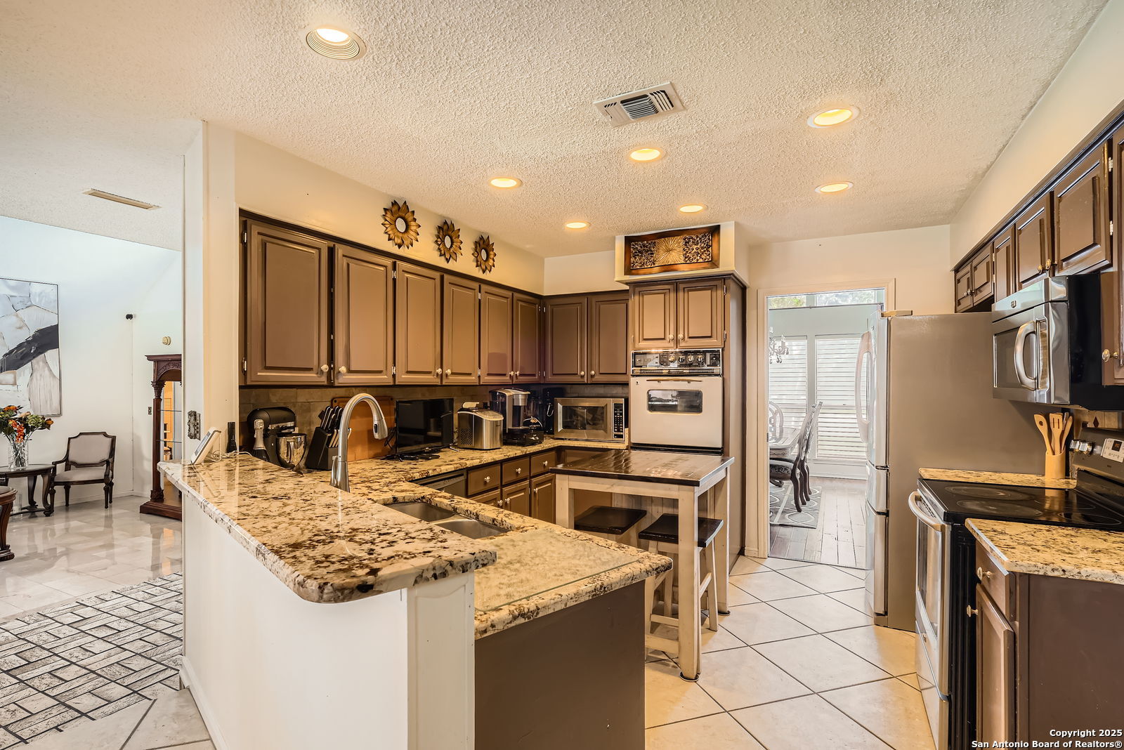 13215 Hunters Spring San Antonio, TX 78230 - Photo 11 of 29 a kitchen with stainless steel appliances granite countertop a sink stove and refrigerator