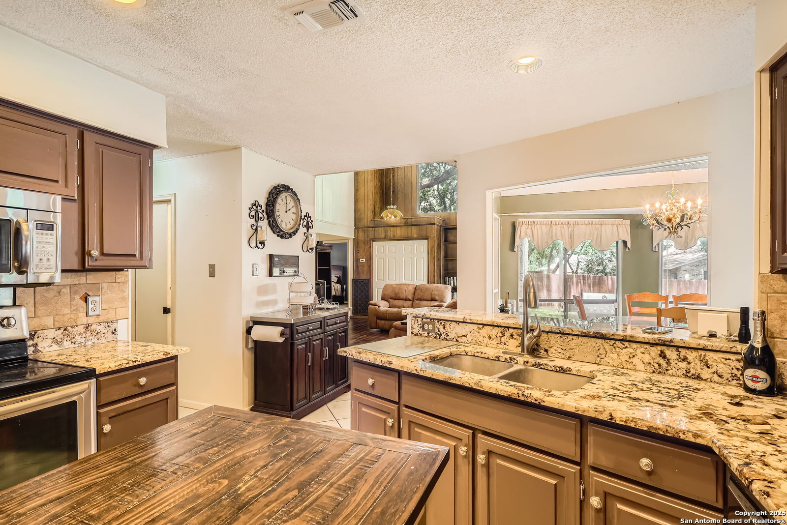 13215 Hunters Spring San Antonio, TX 78230 - Photo 13 of 29 a large kitchen with kitchen island granite countertop a large window and a sink