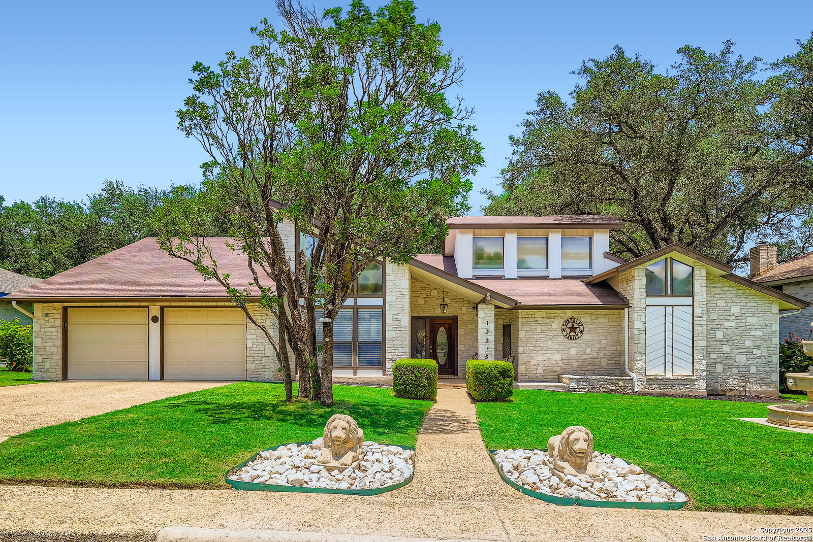 13215 Hunters Spring San Antonio, TX 78230 - Photo 3 of 29 a front view of a house with a garden and trees