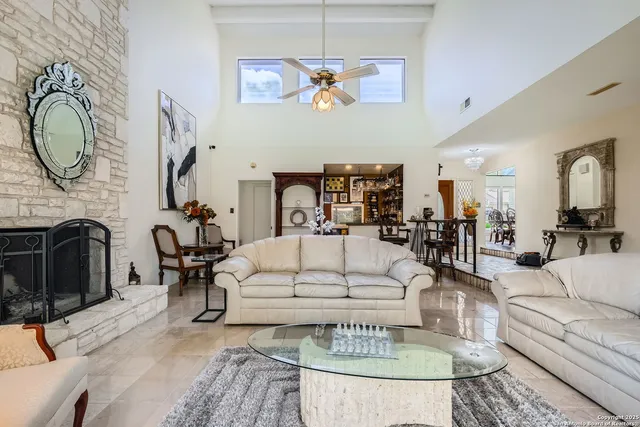 a living room with furniture a fireplace and a chandelier