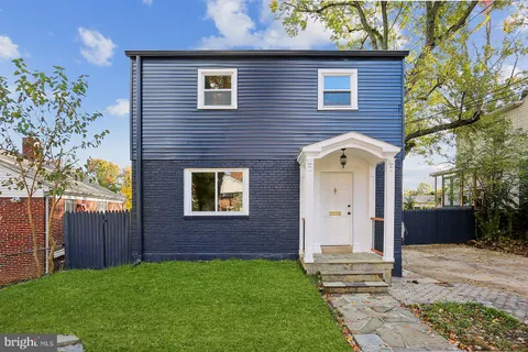 a view of a house with a yard and wooden fence