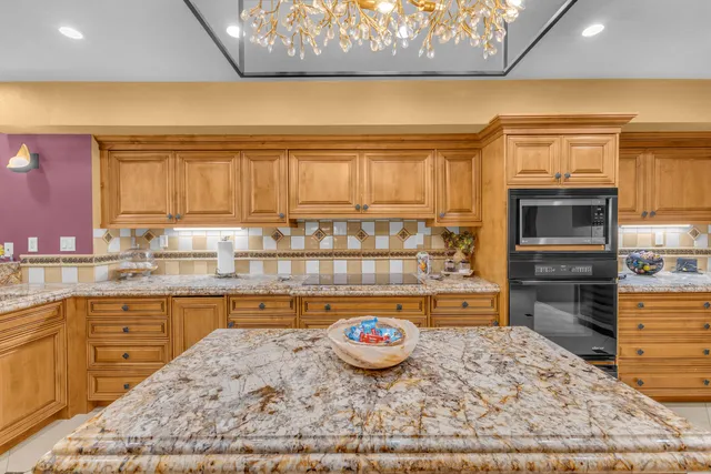 a kitchen with stainless steel appliances granite countertop a refrigerator and a stove