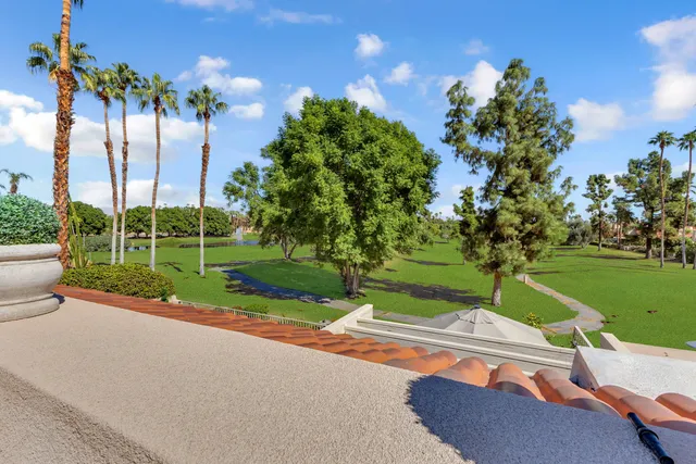 a spacious bedroom with a bed and a flat screen tv