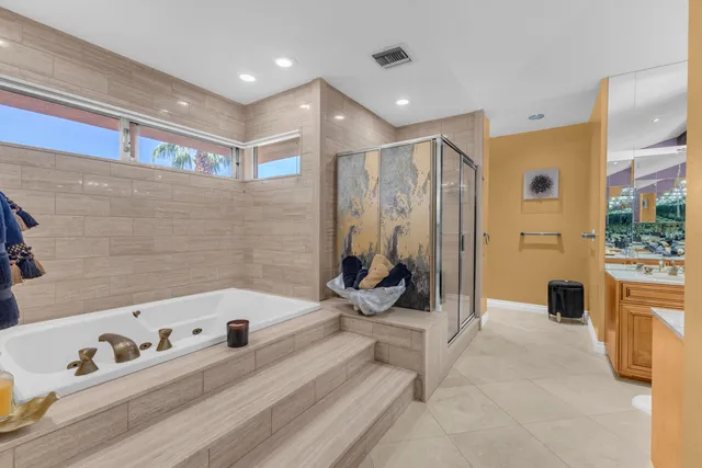 a bathroom with a tub a mirror and shower