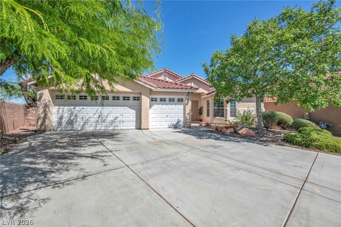 6405 North Raptor Court North Las Vegas, NV 89084 - Photo 53 of 66 A terracotta-tiled roof crowns this residence with a two-car garage, mature trees, and drought-tolerant landscaping.