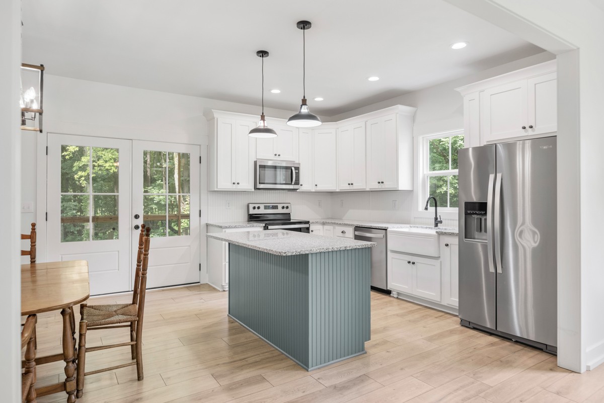 4486 Beards Chapel Road Springfield, TN 37172 - Photo 19 of 54 a kitchen with stainless steel appliances granite countertop a refrigerator a sink dishwasher a stove and white cabinets with wooden floor