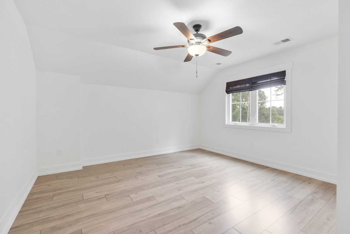 4486 Beards Chapel Road Springfield, TN 37172 - Photo 37 of 54 an empty room with wooden floor chandelier fan and windows