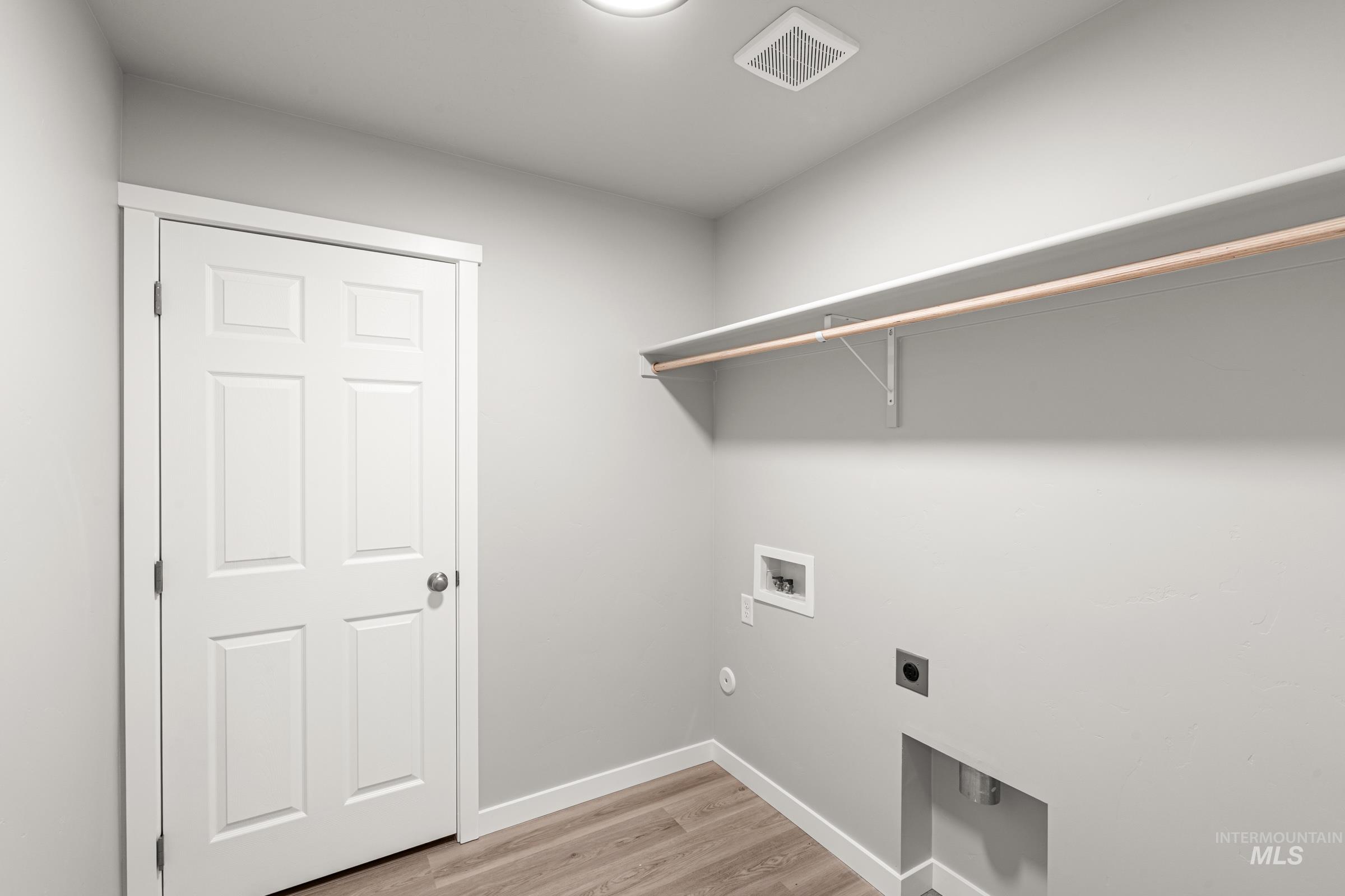 924 Northeast Trailridge Court Mountain Home, ID 83647 - Photo 11 of 21 Laundry room with light wood-style flooring, electric dryer hookup, and washer hookup